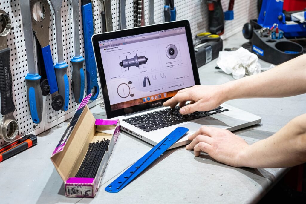 Person working on a laptop surrounded by creative tools, representing the use of AI tools to research, write, design, and build professional presentations more efficiently.