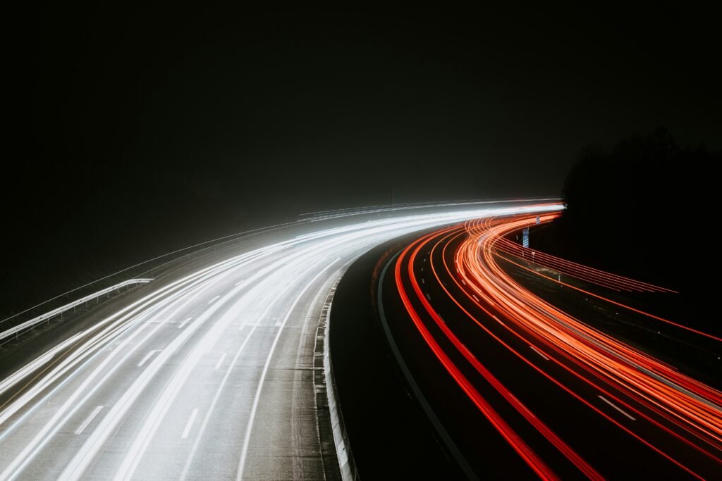 Time-lapse view of traffic lights streaking through a busy city street, representing the speed, efficiency, and fast-paced performance of Google Gemini AI in handling everyday tasks.
