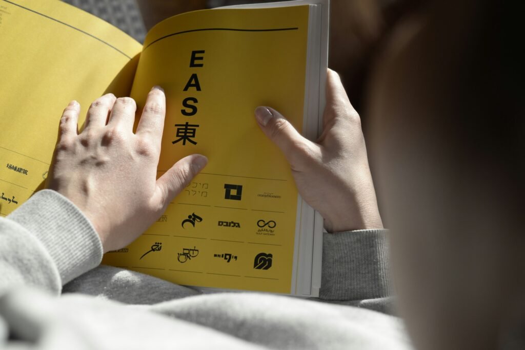 Person holding an open book while reading, symbolizing learning, creativity, and using AI tools like Midjourney or DALL·E for education, inspiration, and content creation.