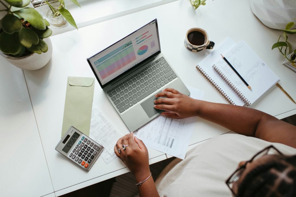 A person working on a laptop at a table, representing business AI, remote work, productivity, and modern digital workflows.