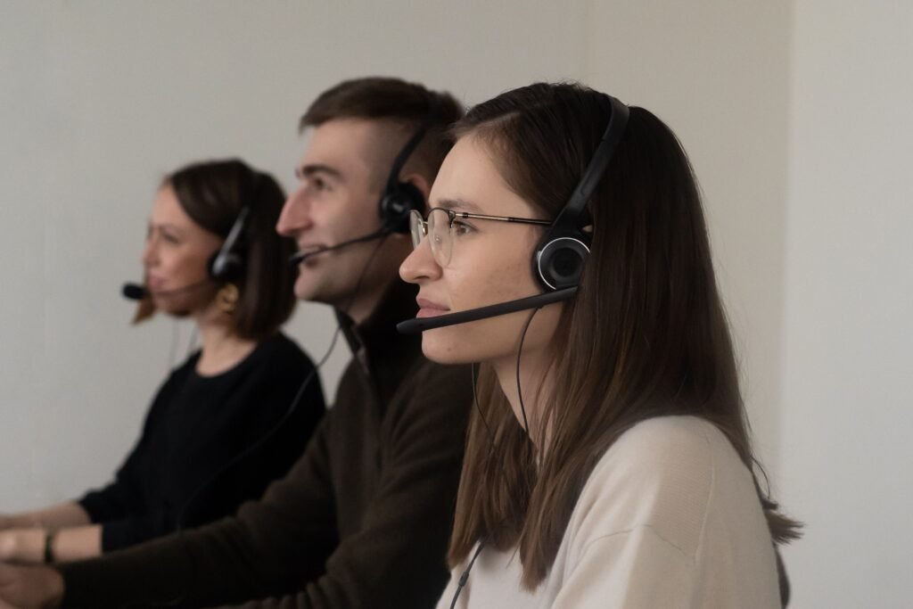 Team of professionals wearing headsets and collaborating at computers, representing creative teamwork, AI-assisted design, and digital content production.
