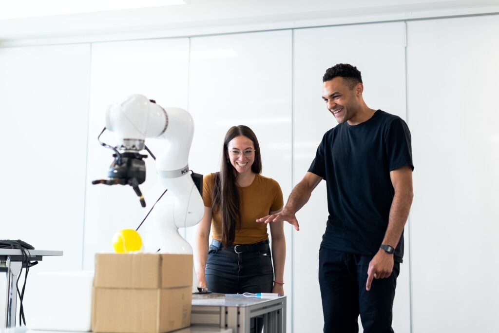 Students working on a robotic arm in a modern laboratory, showcasing robotics, artificial intelligence development, automation, and advanced engineering technology.
